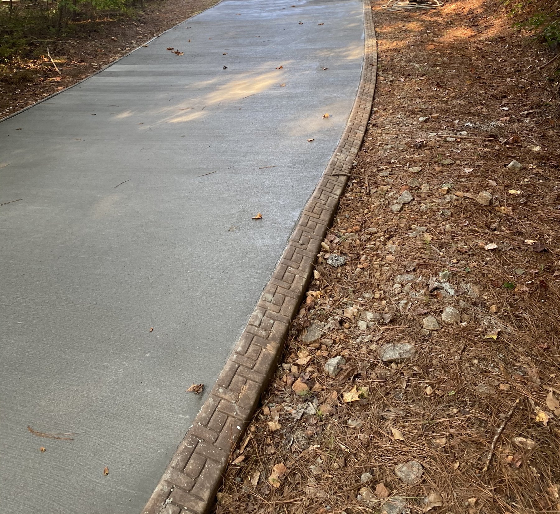 Curved walkway finished concrete photo 2 Curved walkway after photo 2 showing finished walkway concrete work by Colquitt Concrete in Georgia